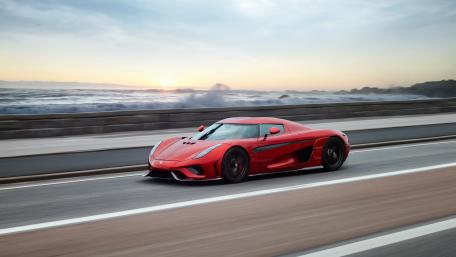 Sleek Red Sports Car by the Ocean Shoreline wallpaper