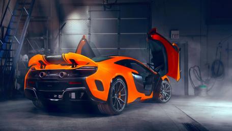 Dynamic Orange McLaren in a Modern Garage Setting wallpaper