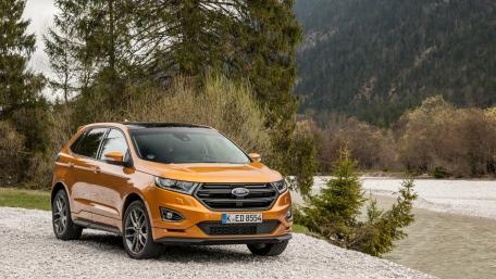 Vibrant Orange SUV by the Riverbank wallpaper