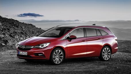 Sleek Red Car Against Scenic Background wallpaper