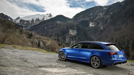 Stunning Blue Car Against Majestic Mountains wallpaper