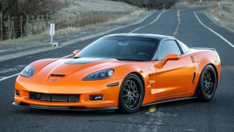 Vibrant Orange Sports Car on Open Road wallpaper