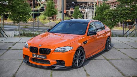 Dynamic Orange BMW M5 in Urban Setting wallpaper