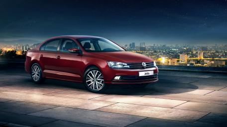 Sleek Volkswagen Jetta Against a City Skyline wallpaper