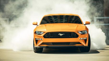 Bold Orange Mustang in Action wallpaper