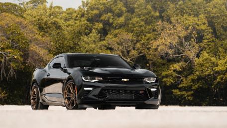 Sleek Black Camaro in Nature's Embrace wallpaper