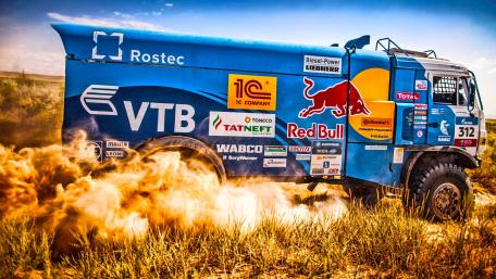 Powerful Truck Racing Through Desert Dusty Terrain wallpaper