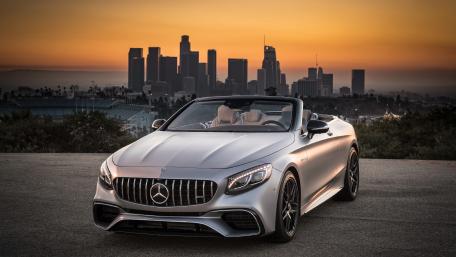 Sleek Convertible Against a Vibrant City Skyline wallpaper