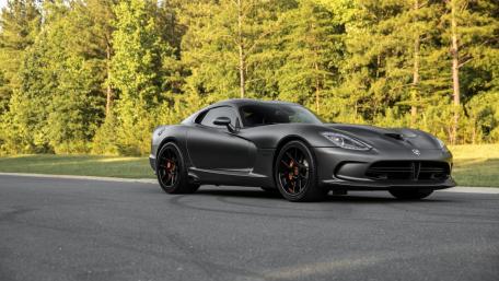 Sleek Black Sports Car in Natural Scenic Setting wallpaper