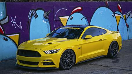 Vibrant Yellow Mustang with Artistic Background wallpaper