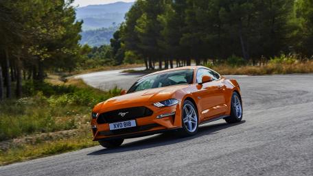 Dynamic Orange Sports Car on Scenic Roadway wallpaper