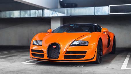 Stunning Orange Bugatti in a Stylish Garage wallpaper