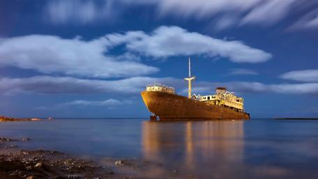 Mysterious Shipwreck Under Moonlit Sky wallpaper