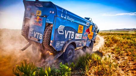 Powerful Rally Truck in Action Amidst Dusty Terrain wallpaper