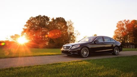 Sleek Luxury Car Under Golden Sunset wallpaper
