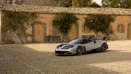 Sleek Supercar in a Rustic Setting wallpaper