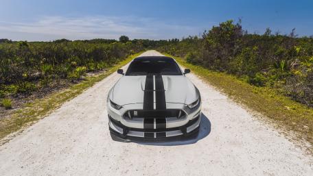 Sleek Mustang on a Dusty Road Ahead wallpaper