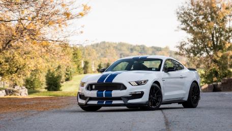 Sleek Performance of a White Sports Car with Blue Stripes wallpaper