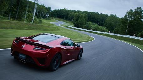 Sleek Red Sports Car on a Curvy Road wallpaper