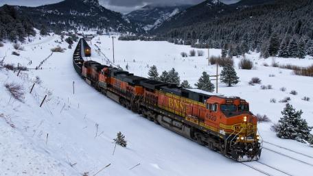 Majestic Winter Train Journey Through Snowy Mountains wallpaper