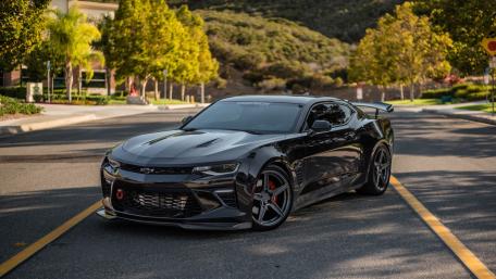 Sleek Black Camaro Capturing Attention on Scenic Street wallpaper