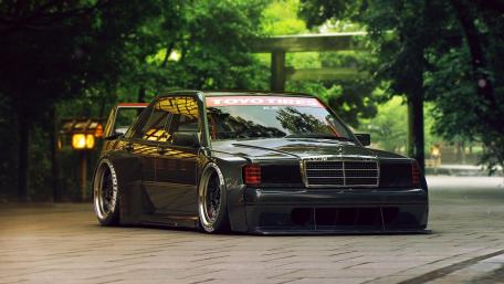 Sleek Black Race Car in Lush Greenery wallpaper