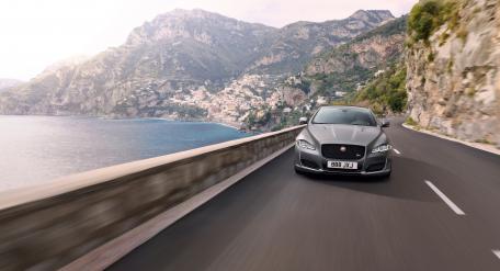 Sleek Luxury Car on Coastal Road wallpaper
