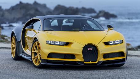 Sleek Yellow Supercar on Coastal Road wallpaper