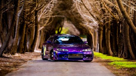 Vibrant Car in a Serene Autumn Pathway wallpaper