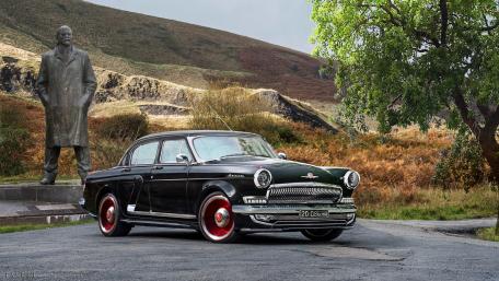 Classic Black Sedan Against a Scenic Backdrop wallpaper