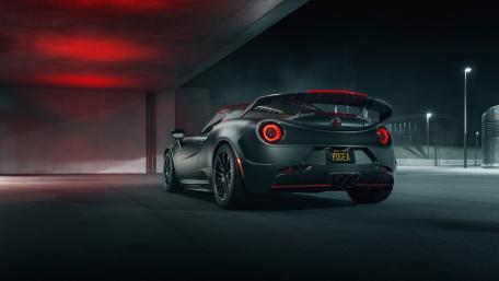 Sleek Black Sports Car Under City Lights wallpaper