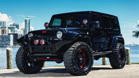 Bold Black Jeep Wrangler Against a City Skyline wallpaper
