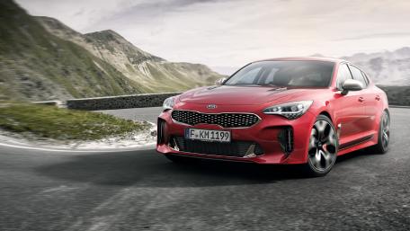 Sleek Red Sports Car on Rugged Road wallpaper