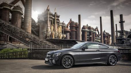 Sleek Car in a Dynamic Industrial Landscape wallpaper