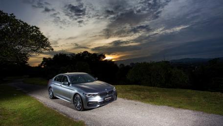 Sleek Silver Sedan Amidst a Dramatic Sky wallpaper