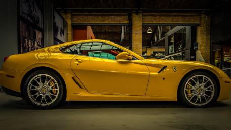 Striking Yellow Ferrari on Display in Modern Garage wallpaper
