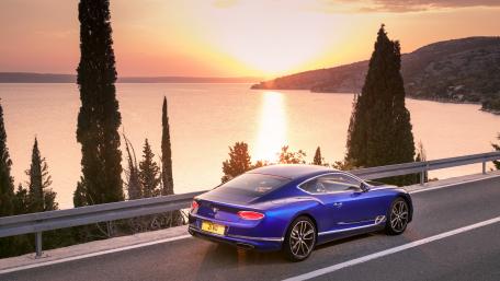 Stunning Blue Car Against a Sunset Shoreline wallpaper