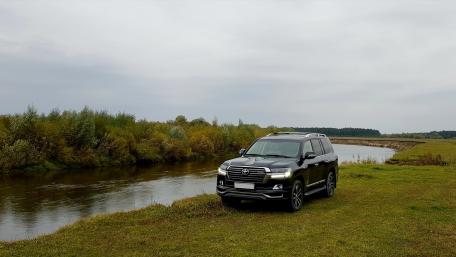 Sleek SUV by a Serene Waterway wallpaper