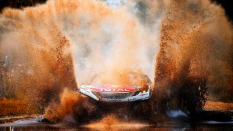 Dynamic Rally Car Splashing Through Muddy Water Scene wallpaper