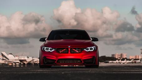 Sleek Red BMW Under Dramatic Clouds wallpaper