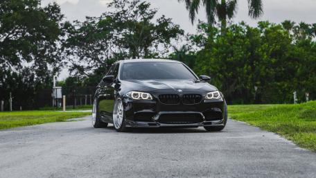 Sleek Black BMW on a Serene Roadside wallpaper