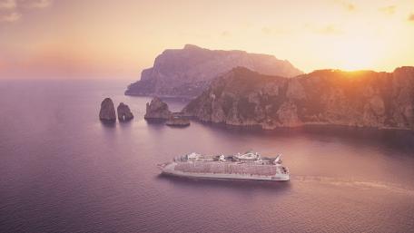Serene Cruise Ship at Sunset Over Hillside Waters wallpaper