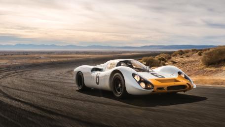Classic Sports Car Racing on Open Road wallpaper