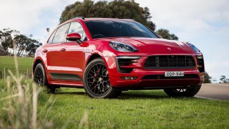 Sleek Red Luxury SUV on Glorious Green Grass wallpaper