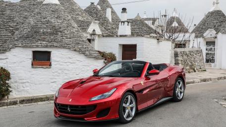 Sleek Red Ferrari in Charming Village Setting wallpaper