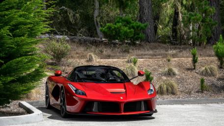 Sleek Red Sports Car in Nature Setting wallpaper
