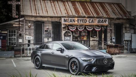 Sleek Luxury Car Against Rustic Bar Background wallpaper