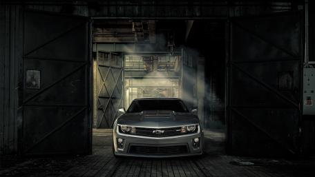 Dynamic Presence of a Classic Muscle Car in Shadowy Setting wallpaper