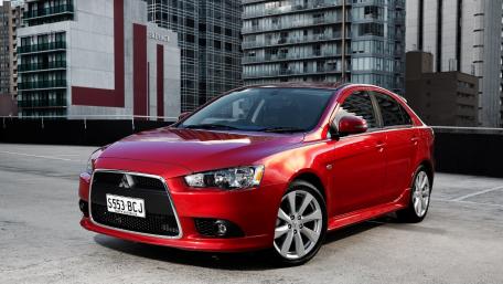 Sleek Red Sedan in Urban Setting wallpaper