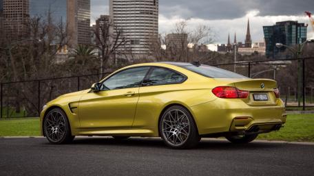 Sleek Yellow BMW Coupe in Urban Landscape wallpaper